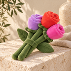 Bouquet de trois roses en peluche, violette, rouge et rose, tenues par un ruban de tige vert